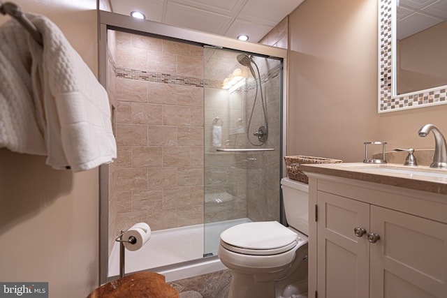 bathroom with vanity, a shower with shower door, and toilet