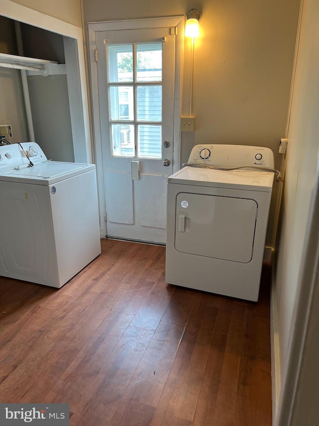 clothes washing area with hardwood / wood-style floors and independent washer and dryer