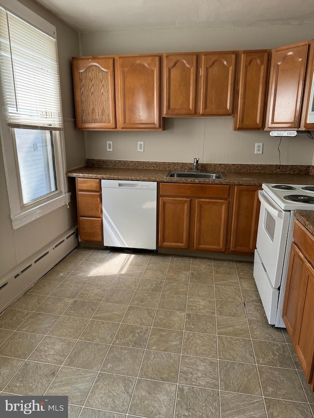 kitchen with baseboard heating, white appliances, and sink