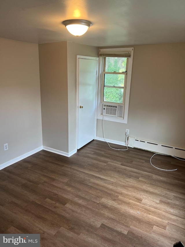 unfurnished room featuring dark wood-type flooring, cooling unit, and baseboard heating