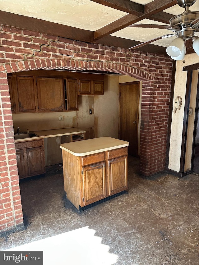 kitchen featuring brick wall, sink, and ceiling fan