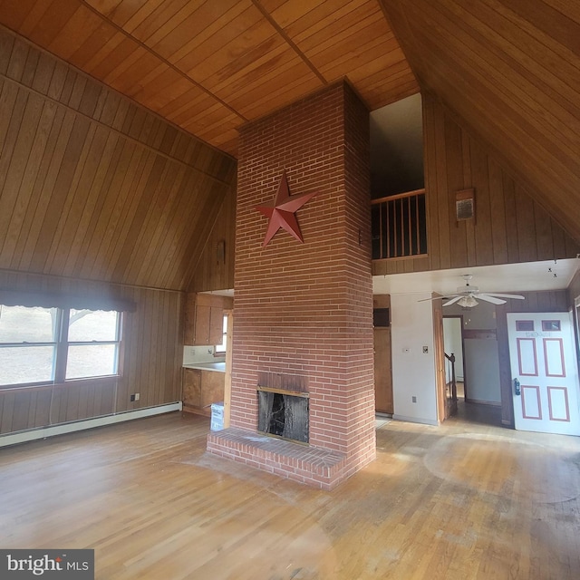 unfurnished living room with light wood-style floors, wooden ceiling, a baseboard heating unit, a fireplace, and high vaulted ceiling