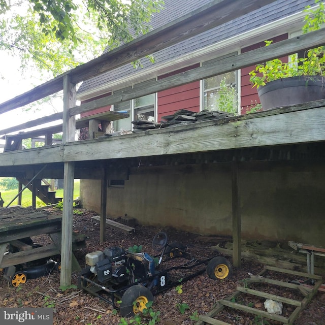 view of side of property with stairs and roof with shingles