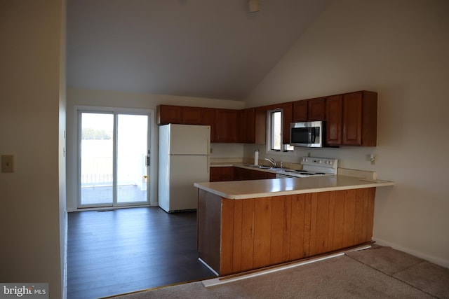 kitchen featuring high vaulted ceiling, sink, white appliances, and kitchen peninsula