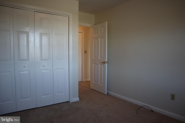 unfurnished bedroom featuring carpet floors and a closet