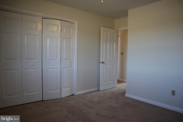 unfurnished bedroom featuring light carpet and a closet