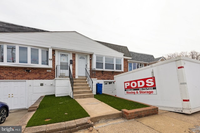 view of front of home featuring brick siding and a shingled roof