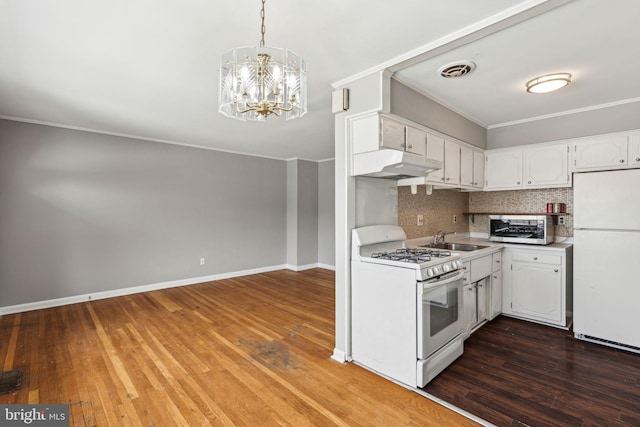 kitchen featuring white cabinetry, pendant lighting, light countertops, under cabinet range hood, and white appliances