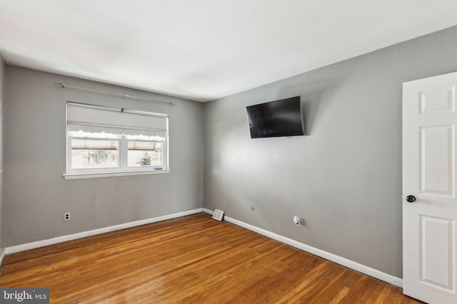 unfurnished room featuring baseboards and wood finished floors