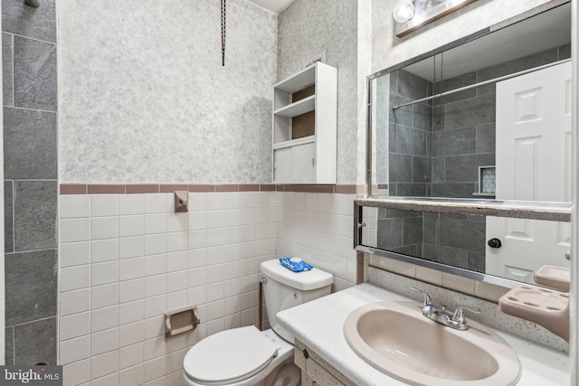 full bath featuring wainscoting, vanity, toilet, and tile walls