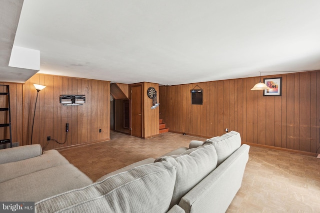 living room with stairway, baseboards, and wooden walls