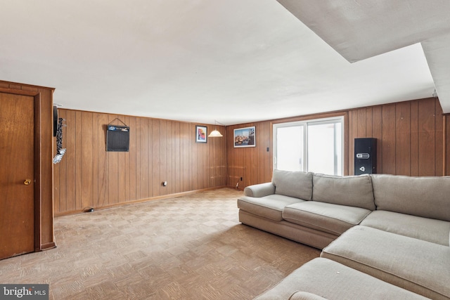 living room with light floors, baseboards, and wooden walls