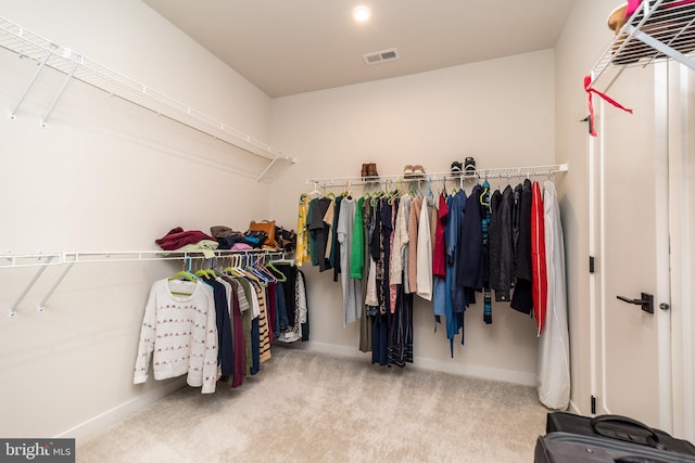 spacious closet featuring light carpet