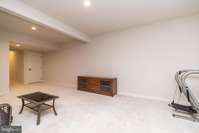 living area featuring light colored carpet and beamed ceiling