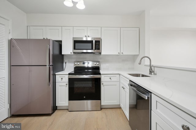 kitchen with appliances with stainless steel finishes, sink, and white cabinets