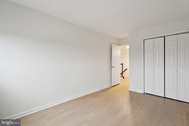 unfurnished bedroom with a closet and light hardwood / wood-style flooring