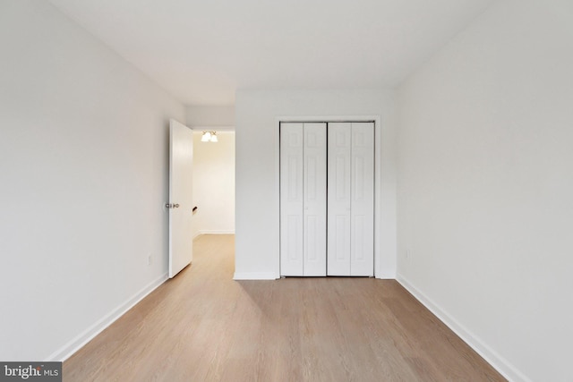 unfurnished bedroom with a closet and light hardwood / wood-style flooring