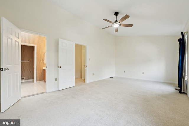 unfurnished bedroom featuring ceiling fan, ensuite bath, and light carpet