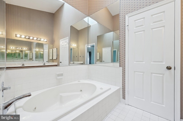 bathroom with a relaxing tiled tub and tile patterned flooring