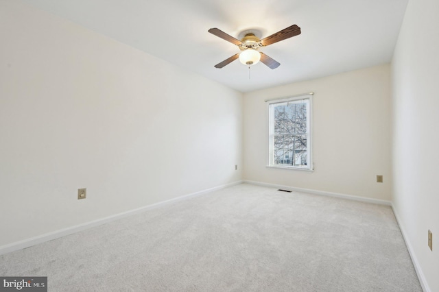 spare room featuring light carpet and ceiling fan