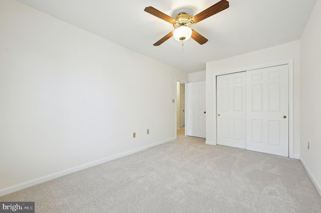 unfurnished bedroom featuring ceiling fan, a closet, and light carpet