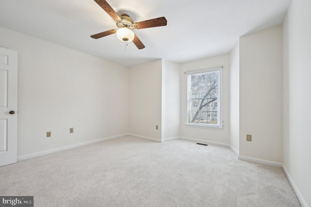 spare room with ceiling fan and light carpet