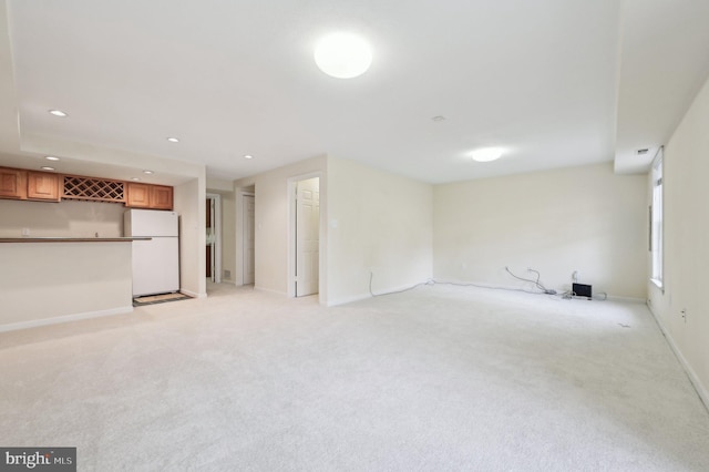 unfurnished living room with light carpet and bar