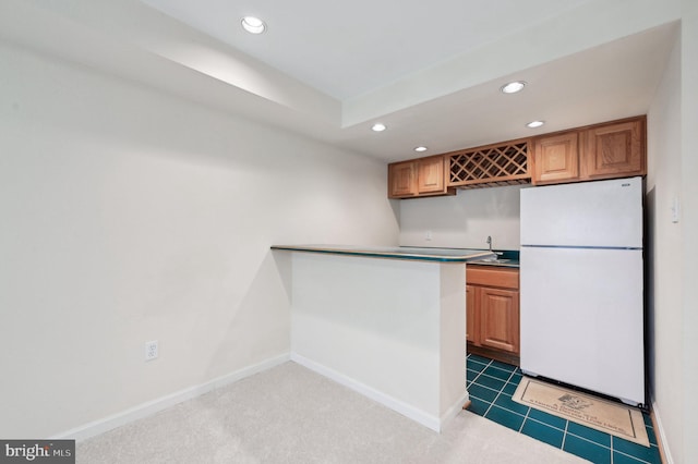 kitchen featuring sink, dark colored carpet, and white refrigerator