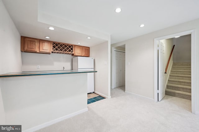 kitchen featuring light colored carpet and white fridge