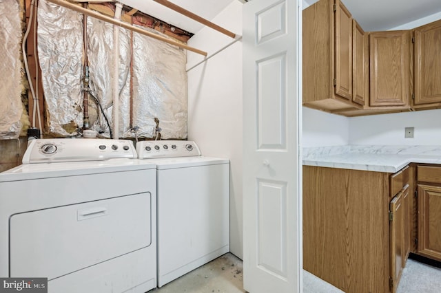 laundry room with separate washer and dryer and cabinets