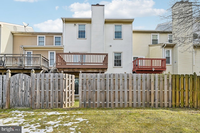 rear view of house with a lawn and a deck