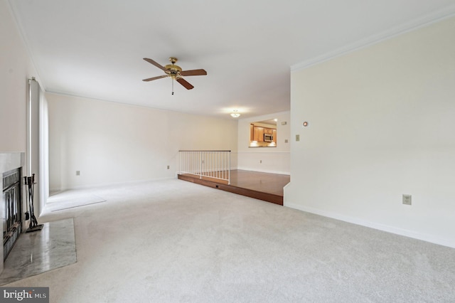 unfurnished living room with ornamental molding, light colored carpet, and ceiling fan