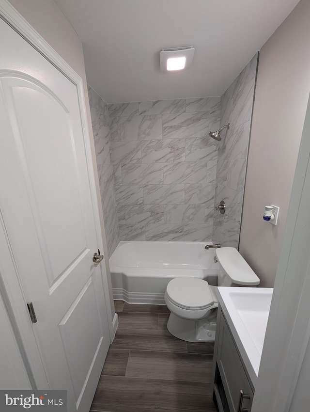 full bathroom with hardwood / wood-style flooring, vanity, toilet, and tiled shower / bath