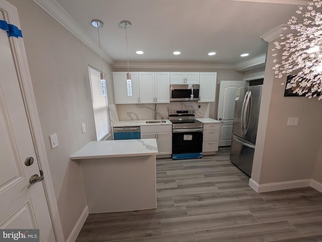 kitchen with white cabinetry, appliances with stainless steel finishes, pendant lighting, and kitchen peninsula