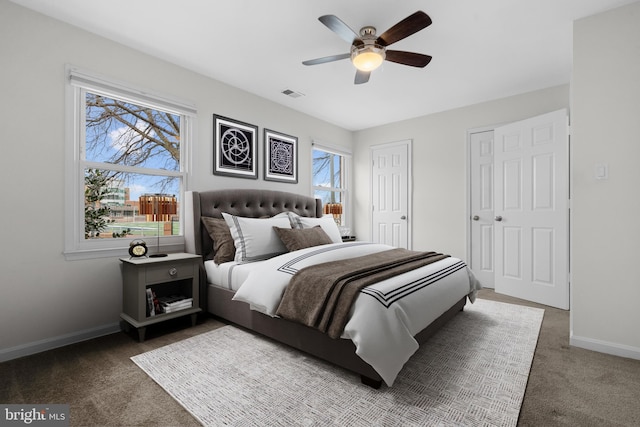 carpeted bedroom with multiple closets and ceiling fan