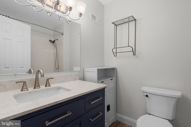 bathroom with a shower, vanity, and toilet