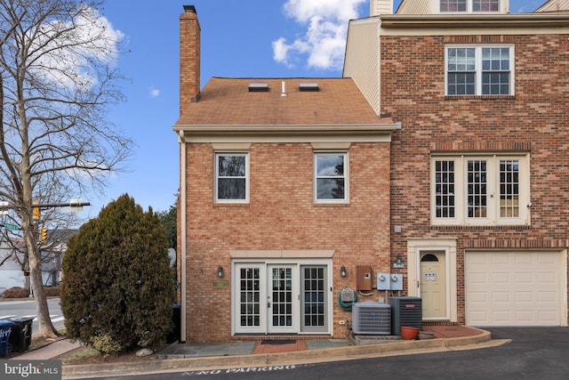 back of house featuring a garage and central air condition unit