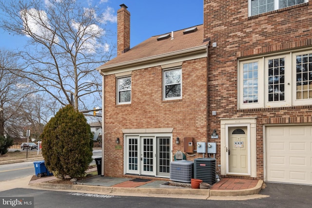 exterior space with a garage and central AC unit