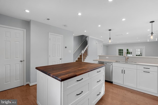 kitchen featuring a center island, dishwasher, sink, and hanging light fixtures