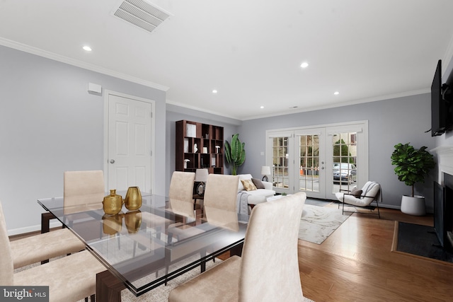 dining room with french doors, crown molding, and hardwood / wood-style floors