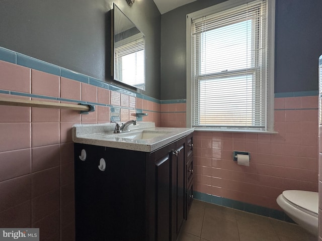 bathroom with tile walls, vanity, and tile patterned floors