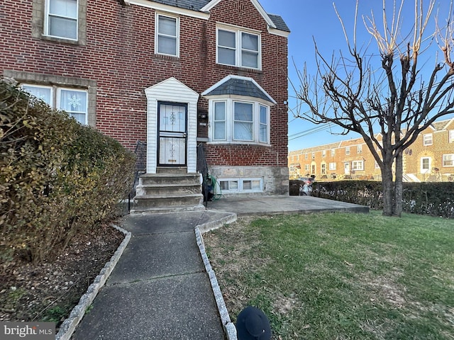 townhome / multi-family property with a front yard and a patio area