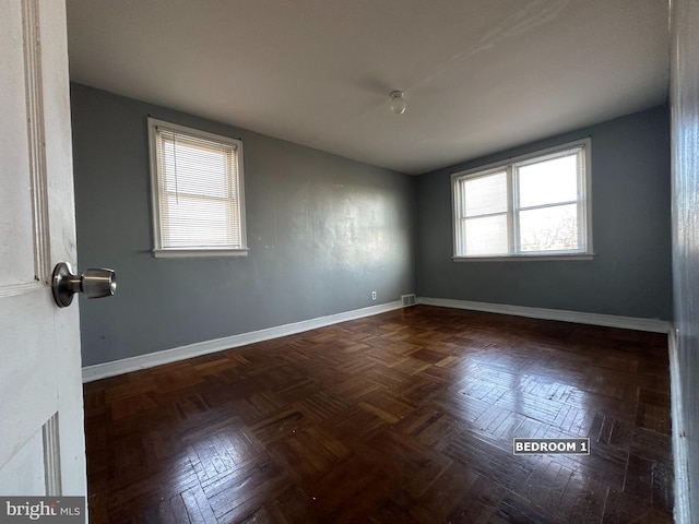 spare room with dark parquet floors