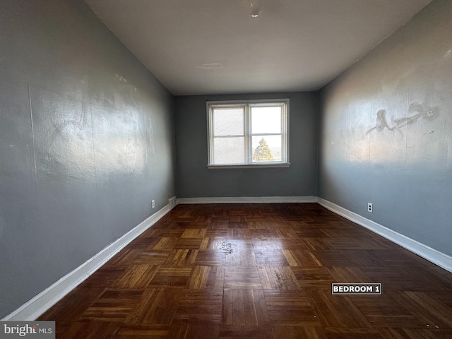 unfurnished room with dark parquet flooring