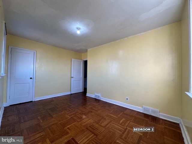 spare room with dark parquet flooring