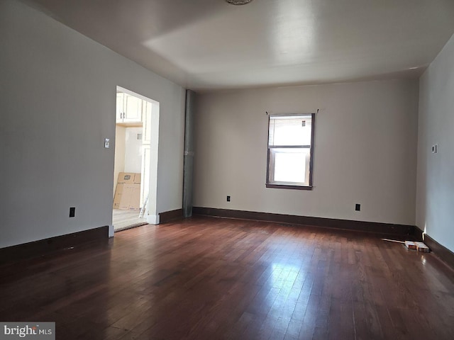 unfurnished room featuring dark wood-type flooring