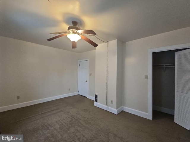 unfurnished bedroom with ceiling fan, a closet, and dark colored carpet