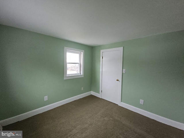 empty room featuring dark carpet