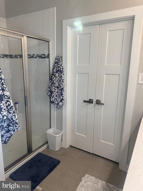 bathroom featuring tile patterned flooring and a shower with shower door