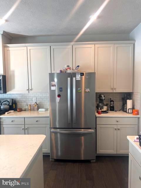 kitchen featuring tasteful backsplash, white cabinetry, dark hardwood / wood-style flooring, and stainless steel appliances